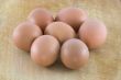 Many fresh rural eggs on the wooden surface