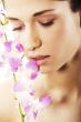 Beautiful young woman with orchid flowers