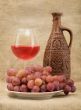 Ceramic bottle, goblet and grapes