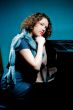 girl with fur scarf near piano thinking