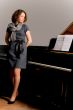 pretty young lady standing thinking near piano