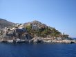 Hydra rocky beach with old buildings