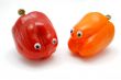 Two funny bell peppers with eyes on white