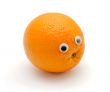 Funny orange fruit with eyes on white