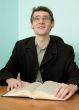 Guy in eyegasses reads the book