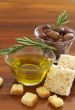 Two jars of black olives and olive oil