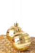 Two gold Christmas baubles on pretty material