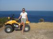 Pretty girl on quadricycle near the sea