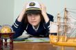 Scared girl in sea uniform at a table