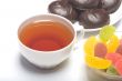 Cup with tea, a zephyr and fruit candy.