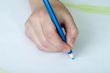 Hand holding a blue pencil