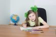 Girl sitting at a table with pencils