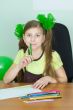 Girl sitting at a table with pencils