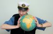 Man in a sea cap compresses globe in hands