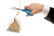 Hand with Scissors Cutting String Holding House