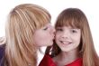 Mother is kissing her happy daughter.