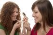 female teenagers making up with Lippgloss