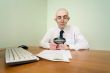 Boss with a magnifier on a workplace