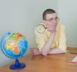 Young man with a magnifier and globe