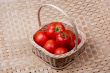 Tomato basket with bamboo mat background