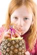 red head girl is drinking from a fresh pineapple on white