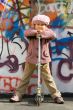 Cute little girl with scooter near graffiti wall