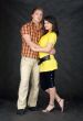 Couple embraces on a black background