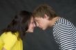 Guy and the girl have faced foreheads on a black