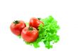 three red tomatos on leaves of lettuce