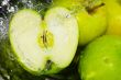 fresh water splash on green apple on metal background