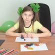 Girl sitting at a table with plasticine