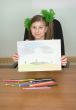 Smiling girl shows new drawing to us