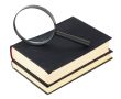 Two black books and magnifier glass on white