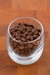coffea beans in glass on wooden table