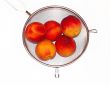 Peaches in colander isolated