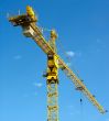 yellow building crane over blue sky background