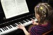 child plays on piano, lesson of the music