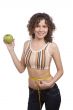 Smiling fit woman with measure tape and apple.