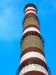 chimney with white and red lines over blue sky