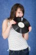 Girl biting a phonograph record on a blue