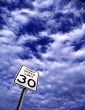Speed Limit Sign Against Cloudy Sky