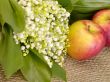 With love. Still-life. lily of the valley and apple on the burla
