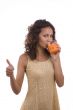 Woman is drinking orange juice and showing OK.