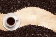 Dark Roasted Coffee Beans and Cup on Wood Background