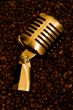 Retro-styled microphone laying on a coffee beans.