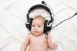 Adorable little girl lying in headphones