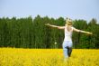 happy young woman is standing on a field