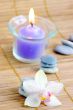spa concept with candles orchids towels and stones on wet wooden