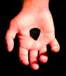 guitar plectrum in hand