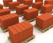 Lot of stacks of orange bricks with pallets isolated